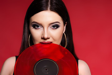 Sexy brunette woman posing in black on red background. Studio sh