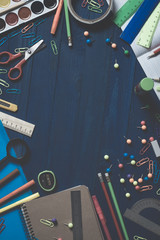 assortment of school stationery such as paper clips, pins, notebook, pens, pencils, rulers, scissors lying on table with space to write text