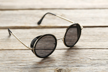 Black sunglasses on a grey wooden table