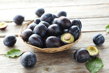 Tasty and ripe plums on grey wooden table