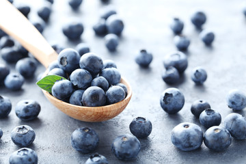 Ripe and tasty blueberries on grey wooden table