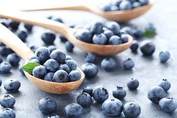 Ripe and tasty blueberries on grey wooden table