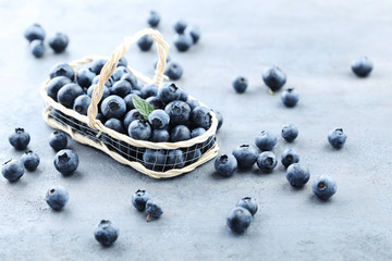 Ripe and tasty blueberries on grey wooden table
