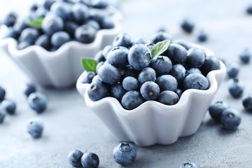 Ripe and tasty blueberries on grey wooden table