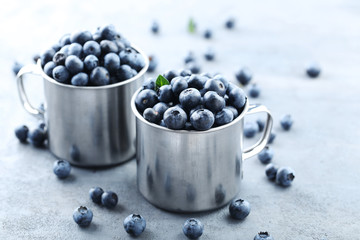 Ripe and tasty blueberries on grey wooden table