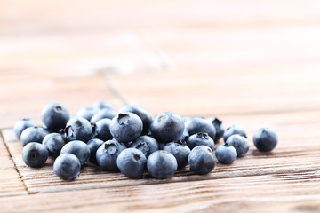 Ripe and tasty blueberries on brown wooden table