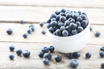 Ripe and tasty blueberries on grey wooden table