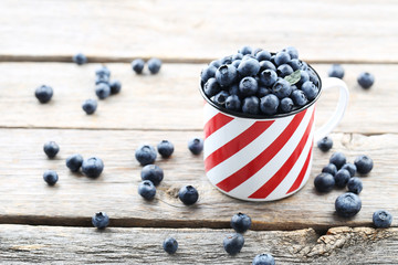 Ripe and tasty blueberries on grey wooden table