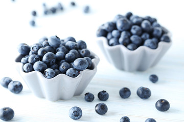 Ripe and tasty blueberries on blue wooden table