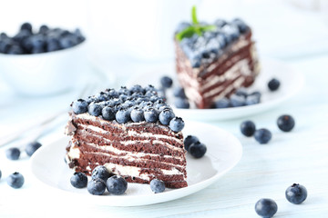 Tasty piece of cake with blueberries on wooden table