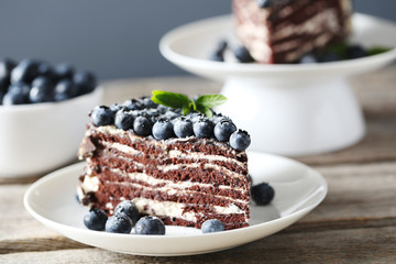 Tasty piece of cake with blueberries on wooden table