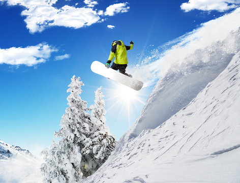 Snowboarder at jump in Alpine mountains