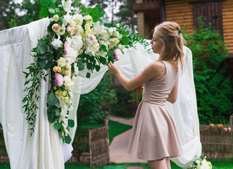 Decorator working with flowers composition for wedding arch.