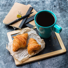 Business stationery croissants mug of coffee on grunge chalkboard