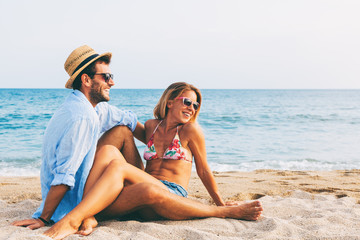 Fototapeta premium Young couple in love lying on the beach, enjoying 