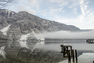 Fog rolling in on water under mountains