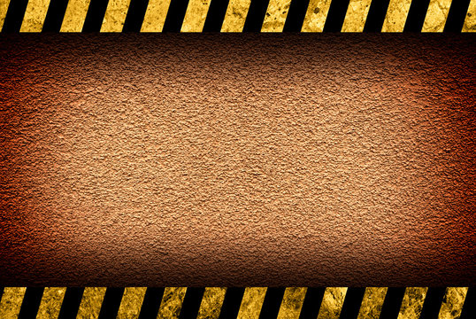 Grunge orange wall background with black and yellow warning stripes