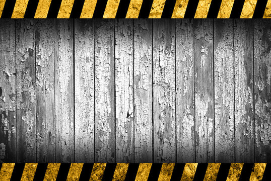 Grunge grey wood background with black and yellow warning stripes