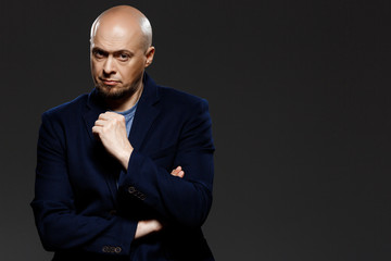 Close up portrait of handsome confident middle-aged businessman over black background.