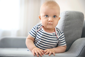 Fototapeta premium Adorable little baby crawling on light sofa