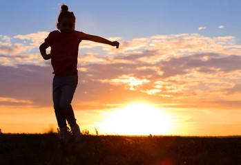 Fototapeta premium Cute girl silhouette on sunset background