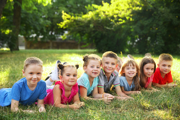 Fototapeta premium Happy kids lying on grass in park