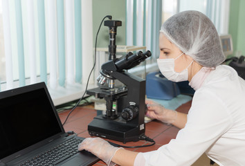 Woman scientist looking in a microscope