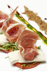 Appetizer-prosciutto, pork smoked cracklings, soft cheese,tomato, rocket, pesto bites, vertical, close up