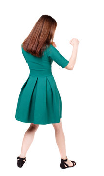 skinny woman funny fights waving his arms and legs. Isolated over white background. The slender brunette in a green short dress has her hands.