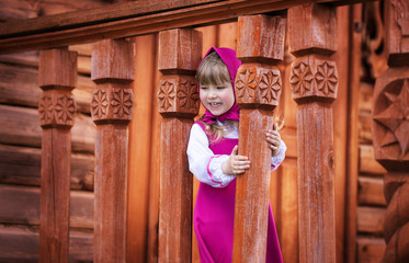 Fototapeta na wymiar Pretty smiling girl playing on the carved wooden porch
