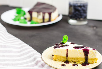 Piece of cheesecake on a black wooden background, selective focus