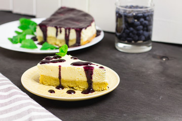 Piece of cheesecake on a black wooden background, selective focus