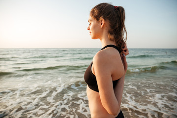 Fototapeta na wymiar Side view of a woman stretching during yoga on beach
