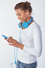 Woman with headphones selecting music on her mobile cell phone