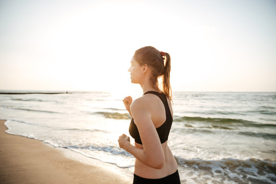 Healthy young woman running on beach
