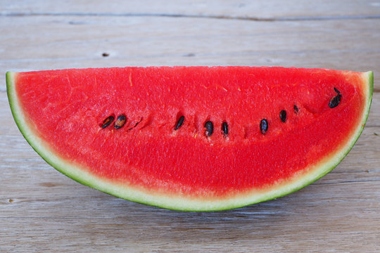 Close up of sliced watermelon on a wooden table.