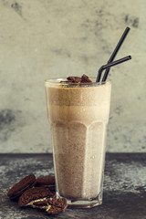 Milkshake with cookies in a tall glass.