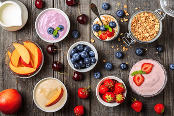 Homemade yogurt with fresh strawberry, blueberry, peach on a woo