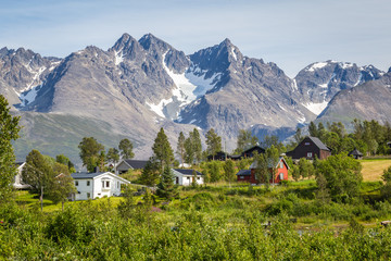 Scandinavian landscape with rapids in a  river and a glacier in the background on the island Lyngen...