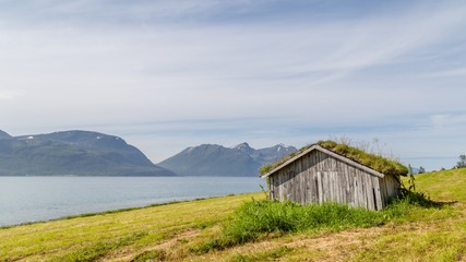 Typical Scandinavian landscape with an old hut with a green roof