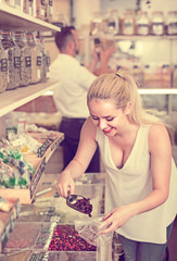 Fototapeta premium Woman picking dried fruits in store .