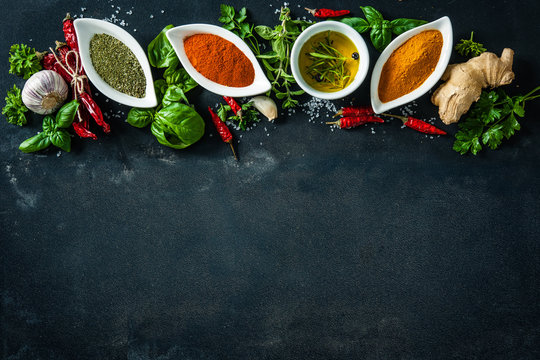 Herbs and spices over black stone background