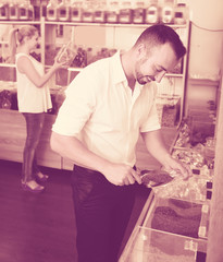 Adult man taking with scoop cereals sold