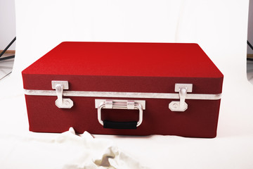 Red suitcase on the white canvas. 3d illustration