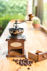 Old Vintage coffee grinder in a wooden case with roasted coffee beans on wooden table. Interior coffee shop. (for Drip Coffee)