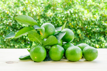 Lomons with slices on wooden table with light bokeh background