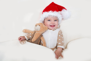 Cheerful Christmas baby and Teddie's bear wearing Santa hats.

