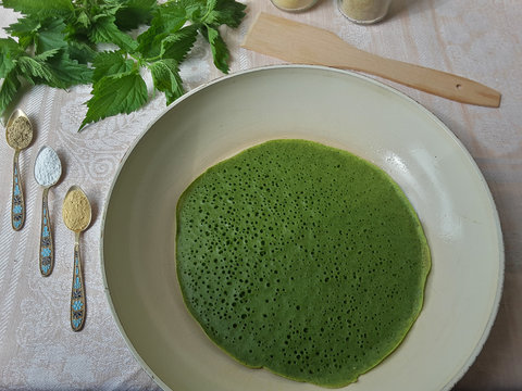Cooking green pancakes with nettle and ground spices, organic food