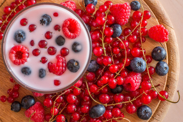 Yogurt with forest berries on wooden table