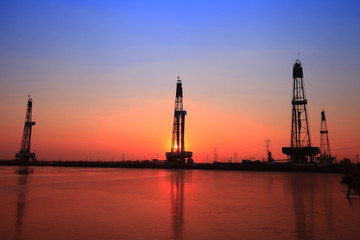 Obraz premium Sunset of oil drilling rig in the sea